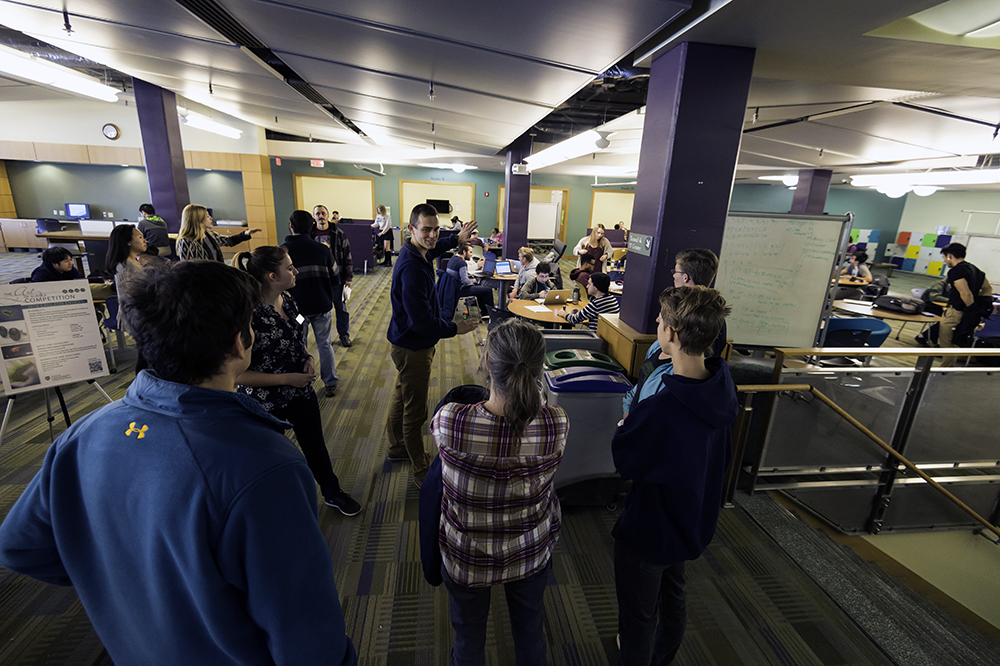 A student showing a tour group the inside of a study area.