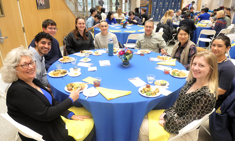 A group of people seated at a table at the banquet enjoying their meal.