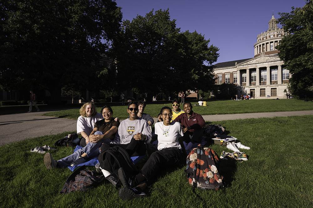 A group of students lounging on the quad on a sunny day.