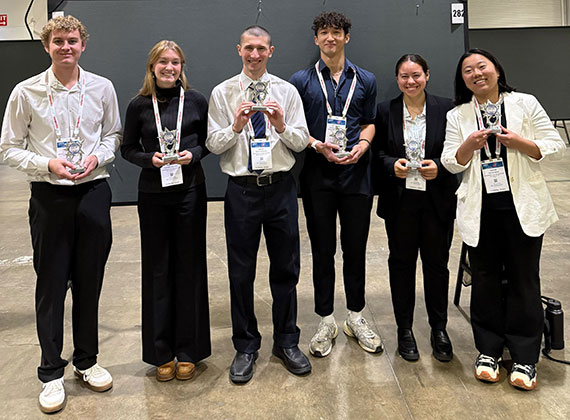 The awards winners holding their awards in a group photo.