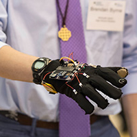 A hand wearing a glove with a circuit board attached.