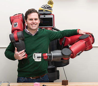 A professor demonstrating a robotic arm.
