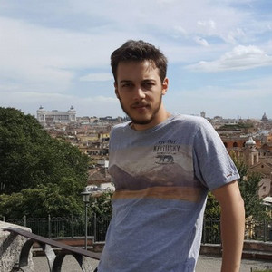 Man smiling at camera in a mountain park setting