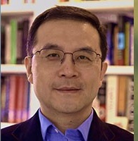 Man looking at camera in front of bookshelf