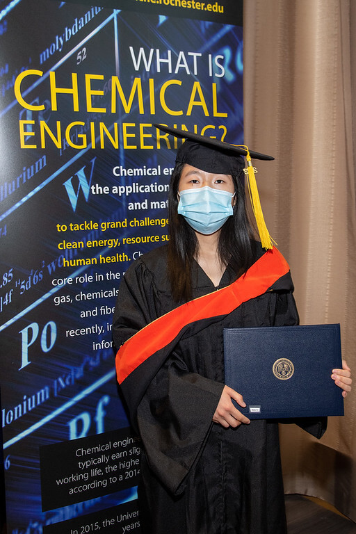 Graduate Xiao standing with their diploma