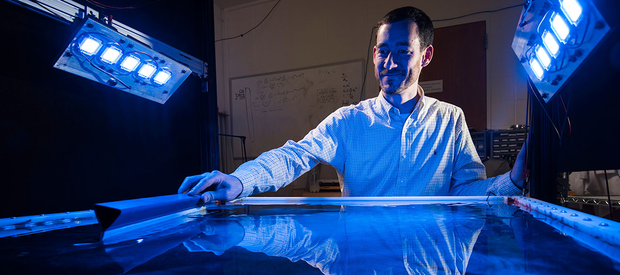 A professor in his lab is pictured with a device used by his research group to model turbulence occurrences to learn how they affect plankton ecology.