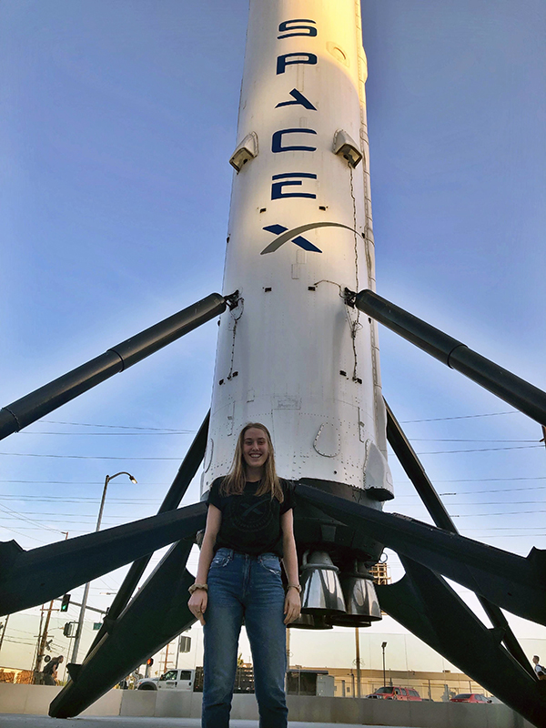 Kate standing in front of a SpaceX rocket.