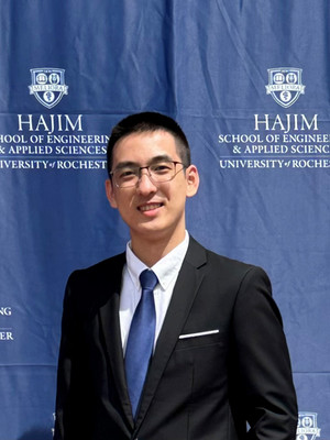 Lin smiling in front of a Hajim School of Engineering banner.