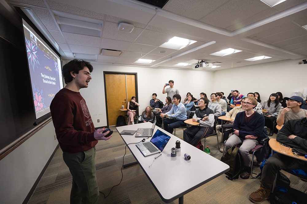 A student giving their final presentation in front of a class.