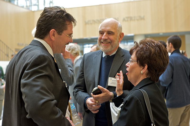 A group of three people chatting at a meeting.