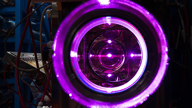 View through the OMEGA laser's 20-cm disk amplifiers shows several electric purple-colored concentric circles.