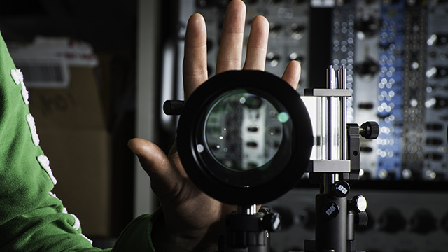 A hand being cloaked using lenses and mirrors.