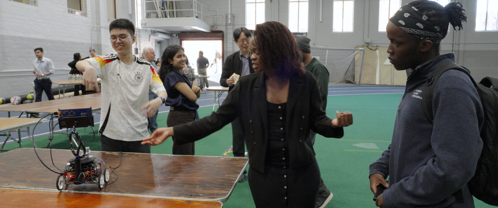 Students demonstrate a small robot at Design Day.