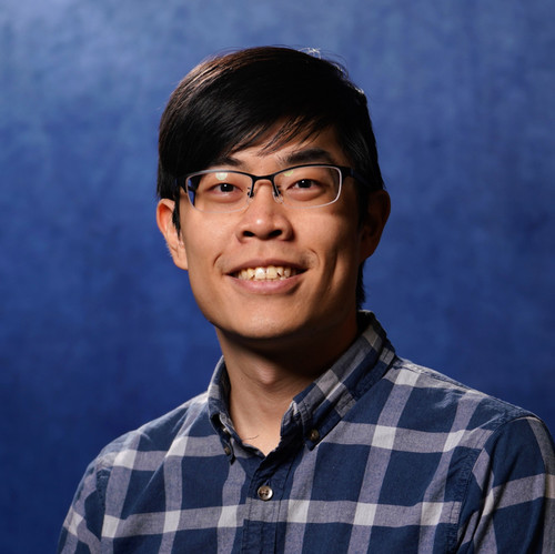 man looking at camera wearing glasses and plaid shirt