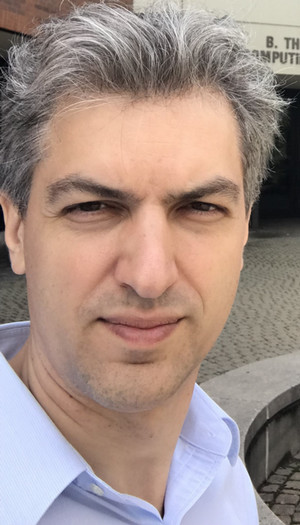 Man smiling at camera wearing white shirt 