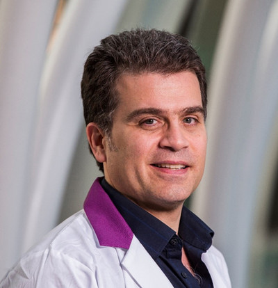 man smiling at camera wearing white lab coat