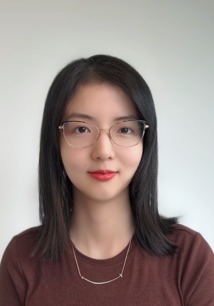 Woman smiling at camera wearing classes and red shirt