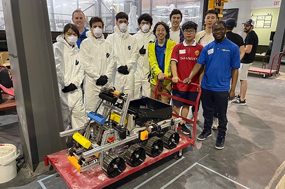 Club members looking at camera as a group with robot