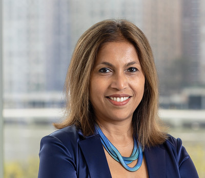 Tanzeem smiling at camera in a blue suit.