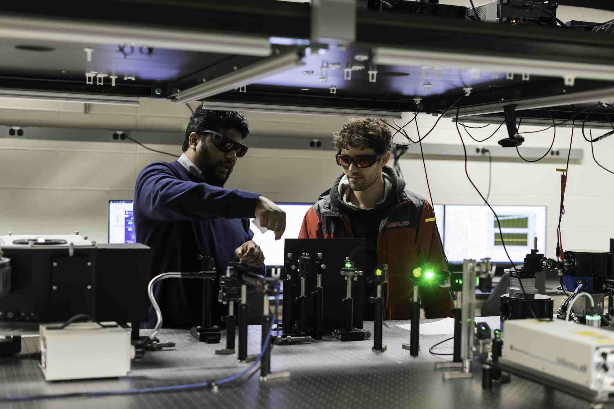 Ranga Dias (left) and Nugzari Khalvashi-Sutter ’23 adjust a laser array in Dias’s advanced spectroscopy lab in Hopeman Hall. (University of Rochester photo / J. Adam Fenster)