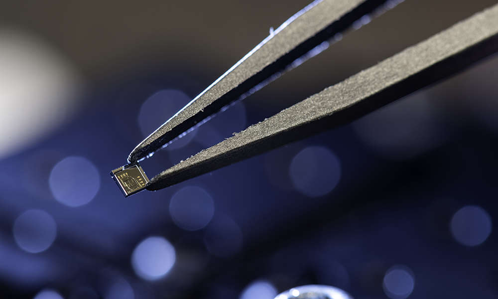 A close up of a 2 mm by 2 mm integrated photonic chip.
